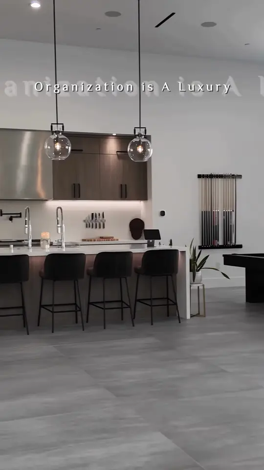 "Organization is a luxury": modern dark-wood kitchen, tall pantry wall, billiards room