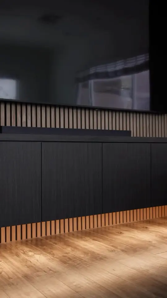 Wood slat media wall with sconces and a black TV surround