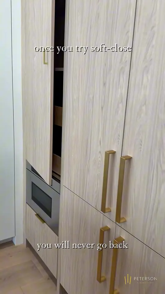 Soft-close hinges and slides, light-wood panels, white slab drawers with brass pulls