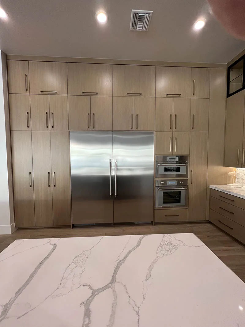 Rift white oak kitchen with matched-grain slab doors by Peterson Cabinet Works