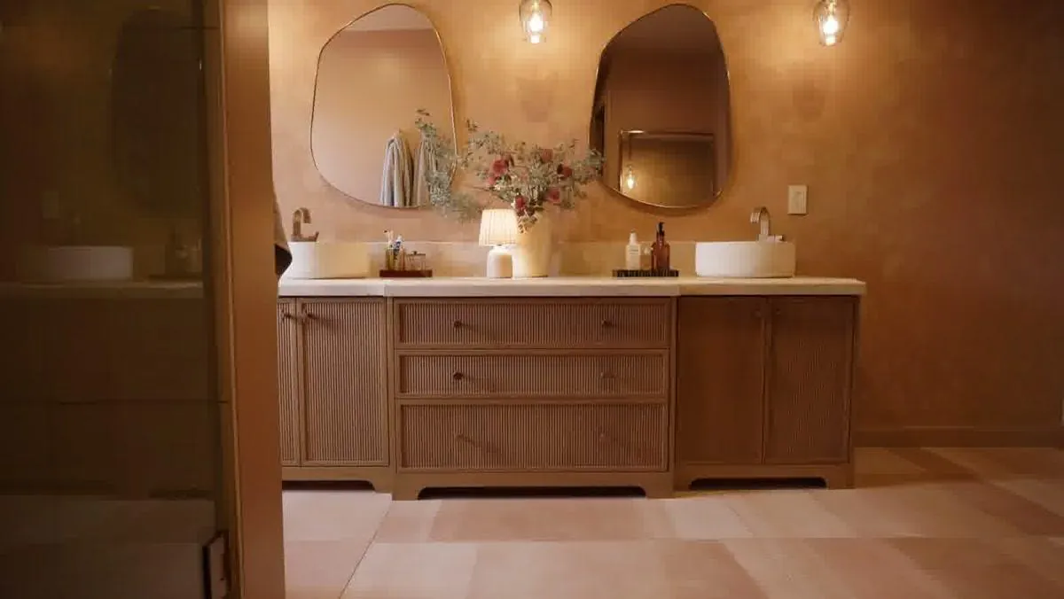 Custom bathroom vanity with arched apron detail and twin mirrors in a remodeled bungalow