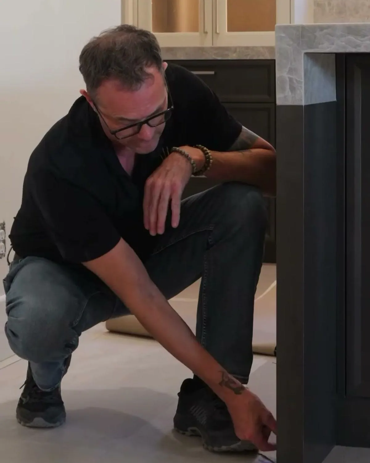 Dave Peterson checking the finished floor line at the base of custom cabinets