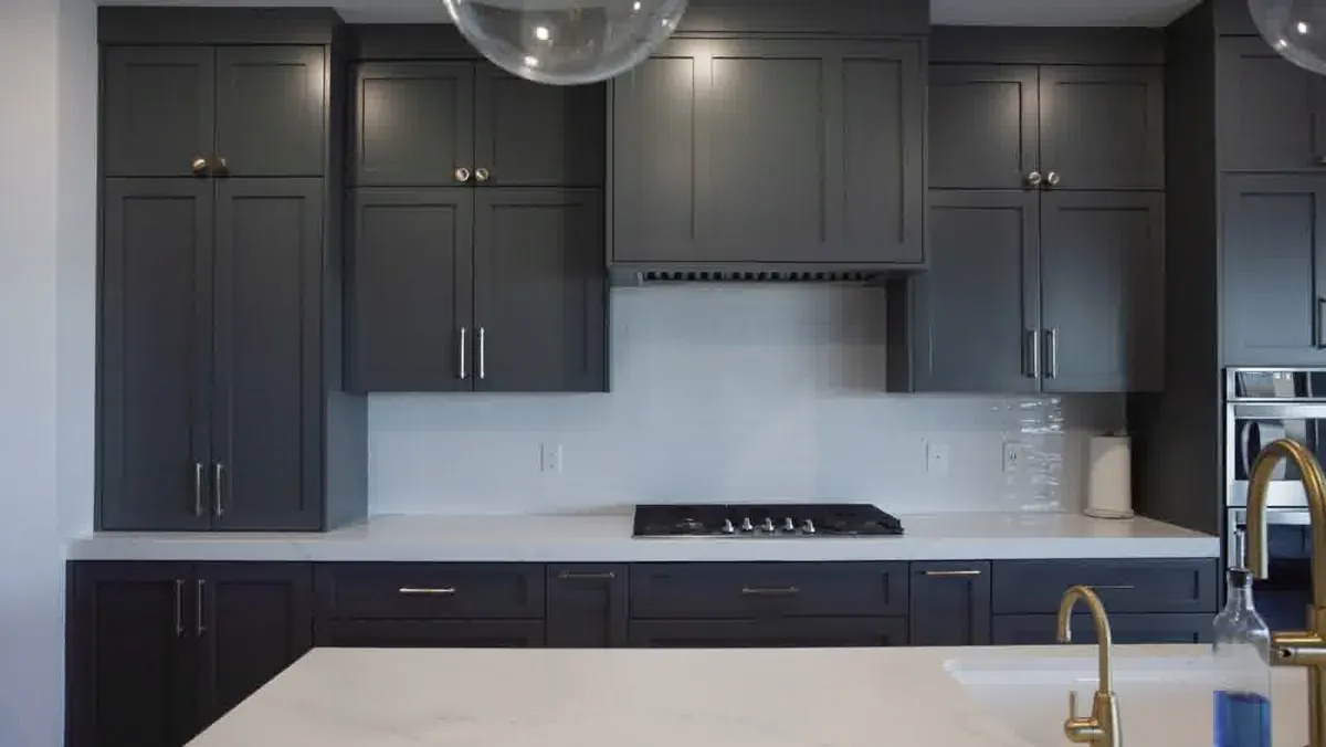 Dark shaker custom kitchen cabinets with brass hardware and waterfall island in a Las Vegas new build