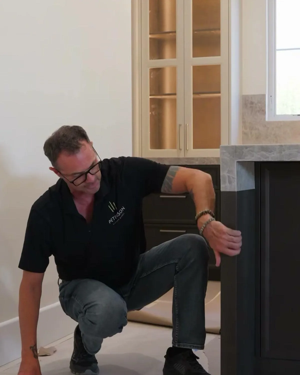 Cabinet installer explaining the kitchen cabinet installation sequence beside an island
