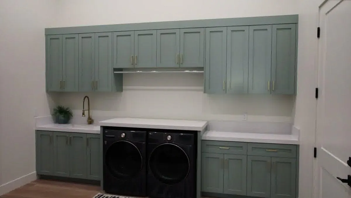Sage green laundry room cabinets built by a Las Vegas custom cabinet maker