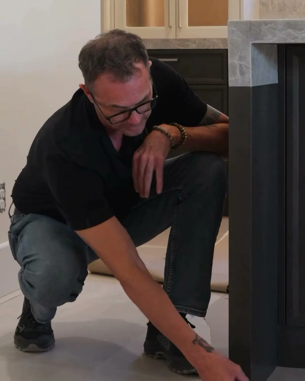 Cabinet maker marking the finished floor height at a kitchen island end panel